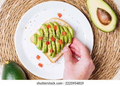 Top view of toast bread slice with avocado and chopped tomato. Healthy breakfast or brunch meal. Colourful and bright scene. 