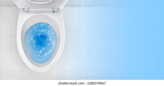 Top view of toilet bowl, blue detergent flushing in it - Shutterstock ID 2186374067