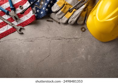 Top view of tools, USA flag, gloves, and hard hat on a concrete surface, symbolizing Labor Day in the United States - Powered by Shutterstock