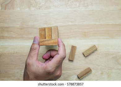 Top view of the tower stack from wooden blocks toy and man's hand take one block
