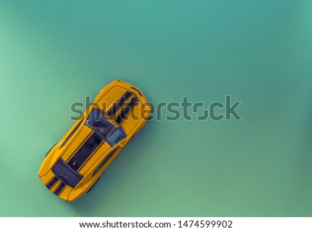 Top view of a toy car on a green paper texture
