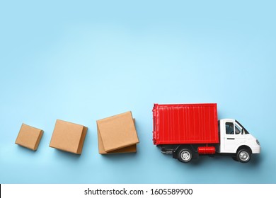 Top view of toy truck with boxes on blue background. Logistics and wholesale concept