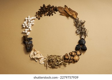 Top view of traditional Chinese medicines arranged in a circle on light brown background. Herbs to help supplement and enhance health. Empty space for text and design. - Shutterstock ID 2279757939