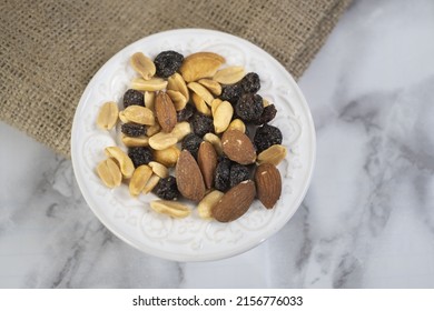 A Top View Of A Trail Mix In A White Plate On A Marble Table