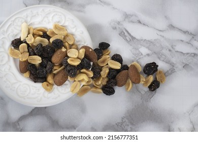 A Top View Of A Trail Mix In A White Plate On A Marble Table