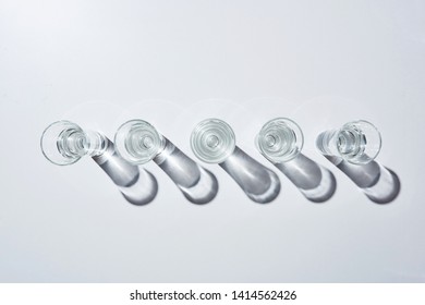 Top View Of Transparent Glasses With Water In Row On White Background With Shadows