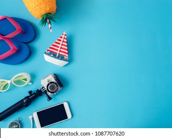 Top View Travel Concept With Action Camera, Smartphone, Passport, Compass And Outfit Of Traveler On Blue Background With Copy Space, Tourist Essentials, Vintage Tone Effect