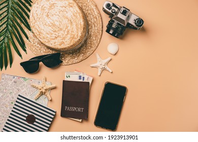 Top View Travel Concept With Retro Camera Films, Map And Passport On Light Orange Background With Copy Space. Flat Lay Tourist Essentials