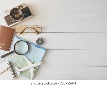 Top View Travel Concept With Retro Camera, Smartphone, Map And Outfit Of Traveler On White Table Wooden Background With Copy Space, Tourist Essentials.