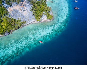 Top view of tropical island with limestone rocks and turquoise clear water. Aerial view of snorkeling people near speedboat above the coral reef. Phi-Phi Don Island, Thailand. - Powered by Shutterstock