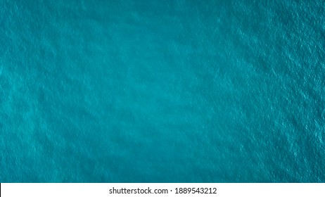Top view of the turquoise water. Like a background. Small waves create ripples on the sea and change color. Gradient from turquoise to dark blue in places. Clean ocean. The background photo. Thailand.
