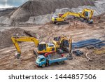 The top view of two backhoe are doing the beach landscape on the ground with a blue truck is waiting beside