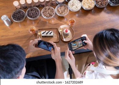 Top view of two Bloggers of young adult asian owner entrepreneur review cafe coffee shop for social media and online marketing in cafe. Using for startup of small business maketing and consumerism.