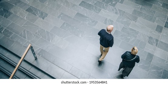 Top view of a two business colleagues walking together across office hallway. Business people arriving to work together. - Powered by Shutterstock