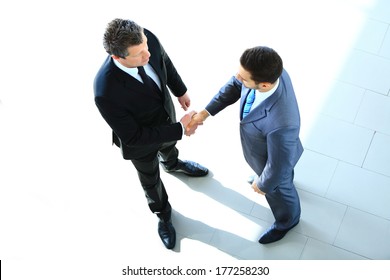 Top View Of A Two Businessman Shaking Hands - Welcome To Business