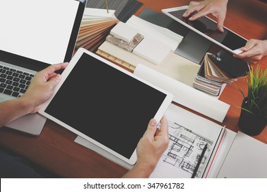 두 명의 동료 내부 디자이너가 빈 스크린으로 된 새로운 현대 컴퓨터 랩탑과 목제 책상 표본 소재를 가진 프로 디지털 태블릿으로 데이터를 토론하는 상위 뷰 스톡 사진