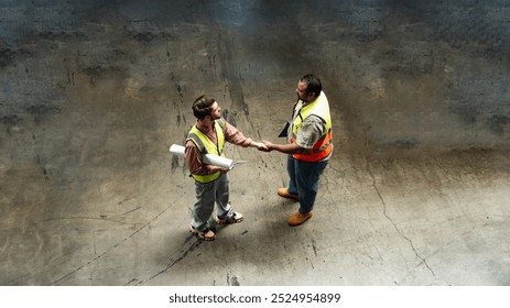 Top view of two factory Worker in warehouse holding blueprints with documents on tablet check list start new Container ship terminal factory project, - Powered by Shutterstock