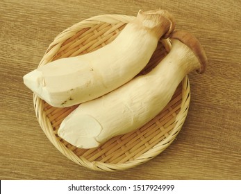 Top View Of Two Fresh Raw King Oyster Mushrooms On Bamboo Plate On Wooden Background. With Low Calorie, High Protein, High Fiber Food, Rich In Vitamin B2. Full Of Nutrition. Cooking Ingredients