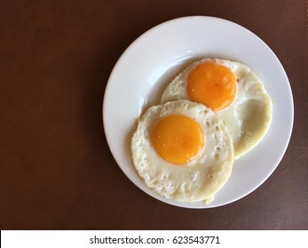 Top View Of Two Fried Egg On White Plate