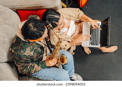 Top view of two latin young musicians using laptop in a record music studio - Powered by Shutterstock
