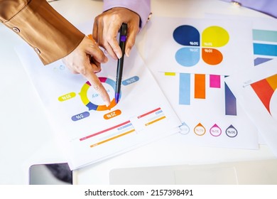 Top view. Two muslim businesswoman accountant pointing paper showing graphic chart on work in the office by analyzing the data sheets, laptops, tablets and graphs on their desks - Powered by Shutterstock