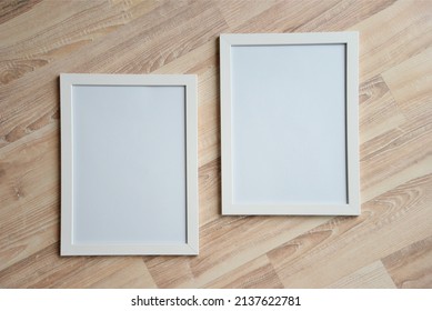 Top view of two photo frames on the wooden floor. Blank frame mockups.