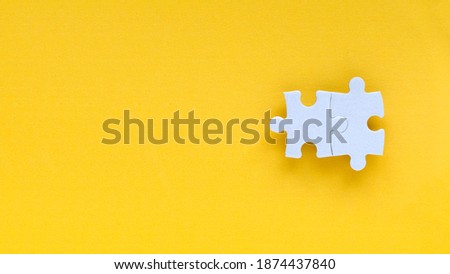 Top view two piece of white jigsaw puzzle isolated on a yellow background with copy space.