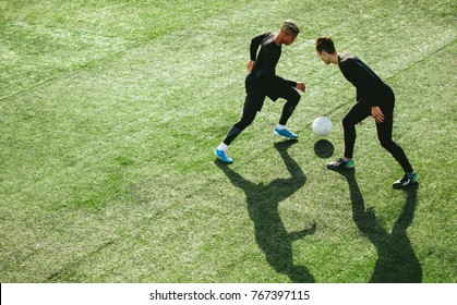 Top view of two teenagers playing football during team practice in field. Young soccer players playing on the sports grass field. - Powered by Shutterstock