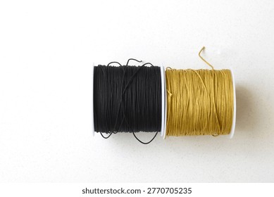 Top view of two thread spools placed on a clean white table. Minimalist composition highlighting texture, symmetry, and sewing materials. Ideal for concepts like tailoring, craftsmanship, DIY, creativity, and modern minimal design with ample copy space.
