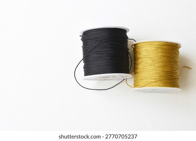 Top view of two thread spools placed on a clean white table. Minimalist composition highlighting texture, symmetry, and sewing materials. Ideal for concepts like tailoring, craftsmanship, DIY, creativity, and modern minimal design with ample copy space.
