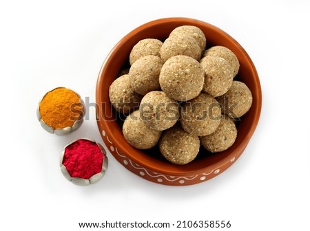 Top view of Two type of till ladoo or Ladu and haldi kumkum arraigned for Indian festival Til sankrati or til sankrant on white background  
