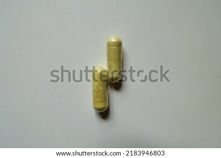 Top view of two yellowish green capsules of quercetin dietary supplement