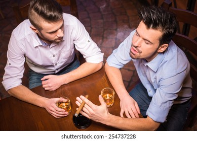 Top View Of Two Young Men In Shirt With Beer While Sitting Together At The Bar Counter.