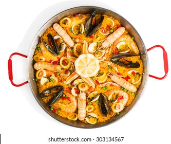 Top view of typical spanish seafood paella in traditional pan isolated on white background