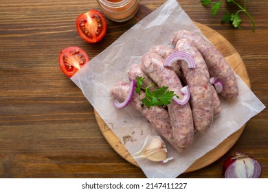 Top view of uncooked bbq sausage on wooden board