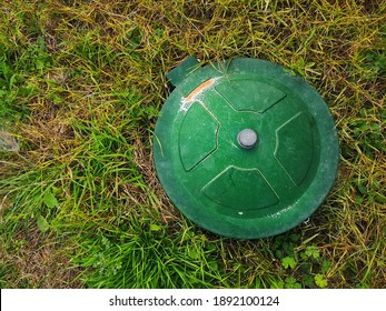 A Top View Of An Underground Gas Tank Cap In A Meadow Under The Sunlight