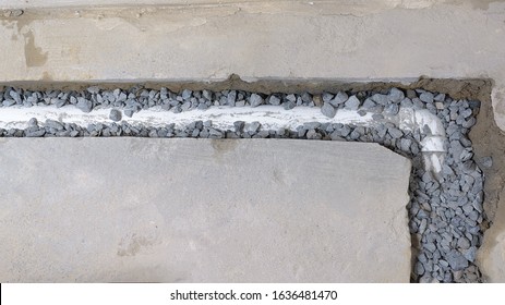 Top View Of An Unfinished French Drain Partially Covered With Drainage Rocks