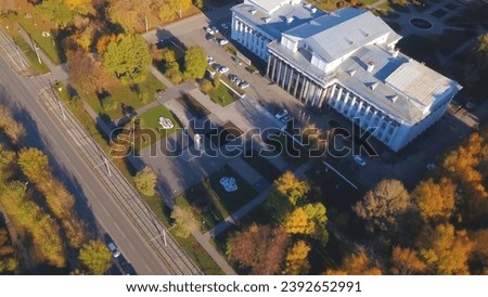 Top view of university building with autumn park. Clip. Beautiful landscape of autumn trees and old building with columns. Old building with columns with autumn forest on sunny day