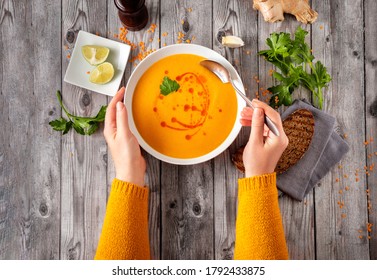 Top View Of Unrecognisable Woman In Orange Sweater Eating Warm And Spicy Winter Lentil Soup