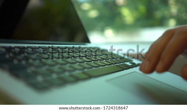 Top view of an unrecognizable\
businessman s hands using his laptop while he is riding a\
train