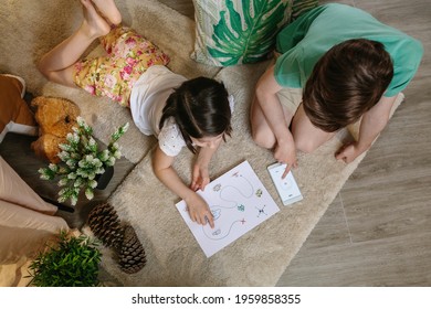 Top View Of Unrecognizable Children Playing Treasure Hunt At Home On The Carpet