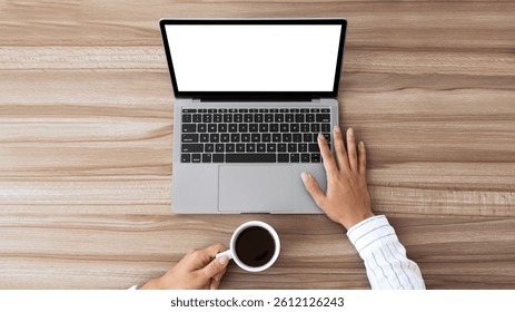 Top view of unrecognizable lady using laptop with white black screen and holding cup of coffee