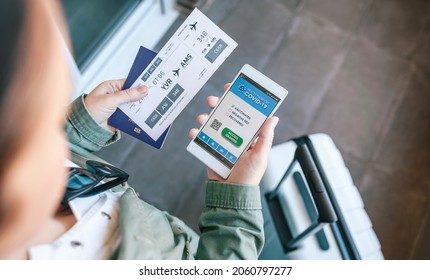 Top View Of Unrecognizable Woman Holding Cell Phone With Covid Passport And Boarding Pass