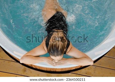 Top view of unrecognizable woman relaxing in the hot tub