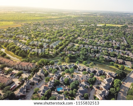 Top view urban sprawl in Dallas-Fort Worth area. Apartment building complex and suburban tightly packed homes neighborhood with driveways flyover. Vast suburbia subdivision in Irving, Texas, US