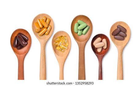 Top view Variety of vitamin and mineral pills in wooden spoon isolated on white background, Dietary supplement healthcare product.