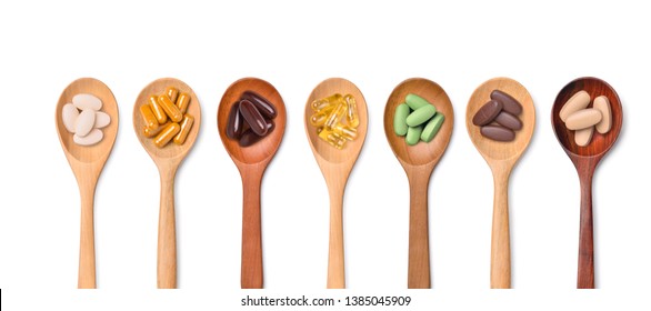 Top View Variety Of Vitamin And Mineral Pills In Wooden Spoon Isolated On White Background, Dietary Supplement Healthcare Product.