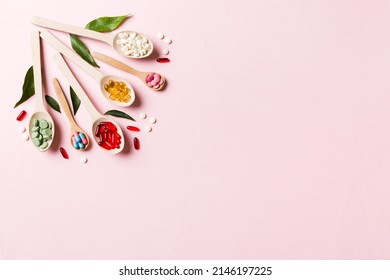 Top View Variety Of Vitamin And Mineral Pills In Wooden Spoon On Colored Background. Top View Of Assorted Pharmaceutical Medicine Pills. Dietary Supplement Healthcare Product.