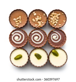 top view of various chocolate pralines on white background