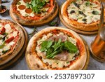 Top view of various neapolitan pizzas on grey stone table